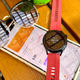 Huawei Watch 3 next to sunglasses and a iPhone showing the Huawei Health app